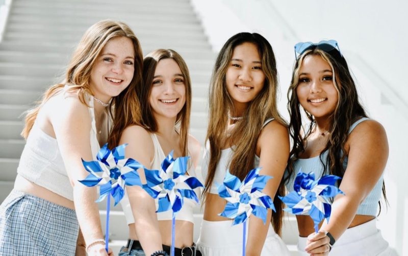 4 SDT members holding blue pinwheels