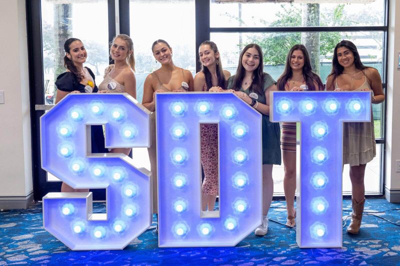 SDT members standing behind large letters saying SDT