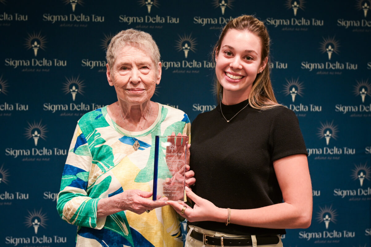 two women standing with award